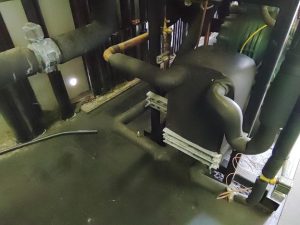 Refrigeration subcooler unit with insulated piping in a commercial system.